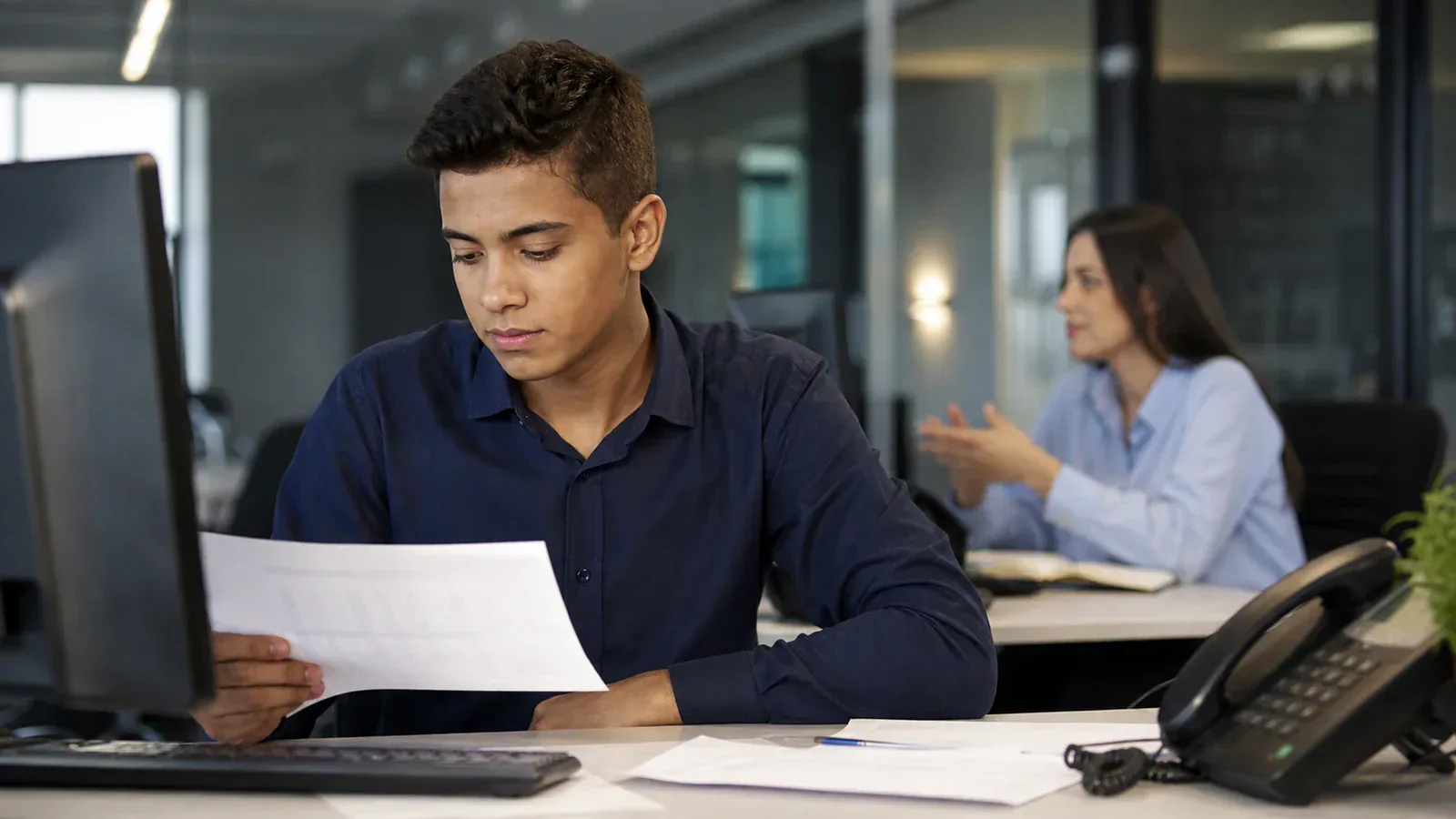 Jovem aprendiz trabalhando em escritório de corretora de seguros