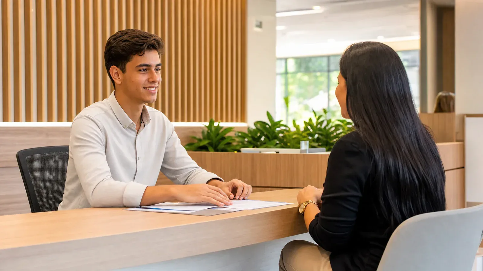 Jovem aprendiz atendendo cooperado em unidade administrativa de Goiânia